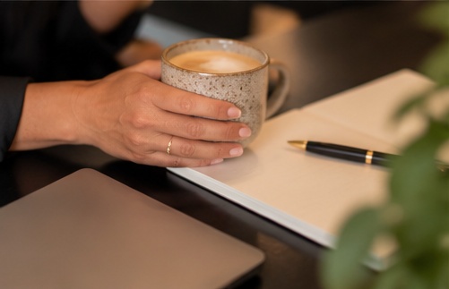 Persoonlijk contact bij een kop koffie, met notitieboek en laptop